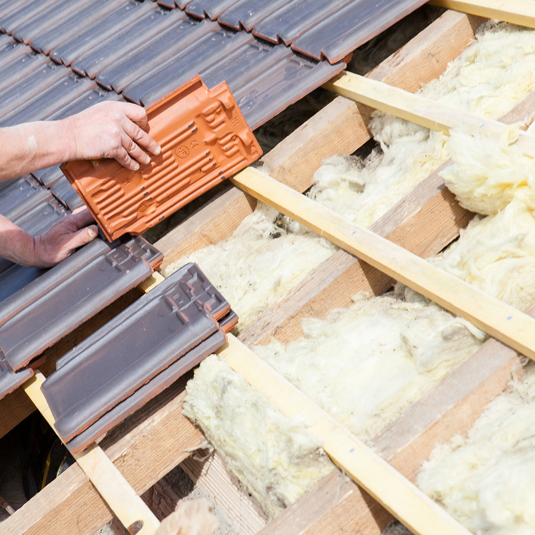a roofer laying tile on the roof